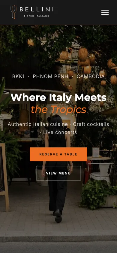 The same home page on a phone: the Bellini logo, the words Where Italy Meets the Tropics over a photo of the garden at night, and buttons to reserve a table and view the menu.
