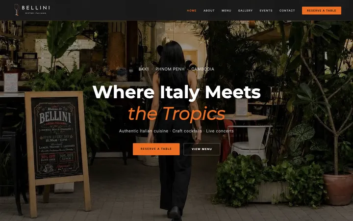 The Bellini Bistro Italiano home page on a computer screen: a menu bar with a Reserve a table button, and the words Where Italy Meets the Tropics over a photo of the leafy garden, with buttons to reserve a table and view the menu.